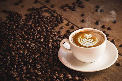Fresh is best... or is it? A cup of coffee with latte art surrounded by roasted coffee beans.