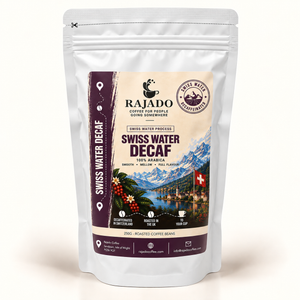 A stand-up resealable pouch of Rajado Swiss Water Decaf coffee beans on a clean white background. The packaging is silver with a large front label featuring a cream background, dark purple side panels, and a scenic Swiss mountain-and-lake illustration.